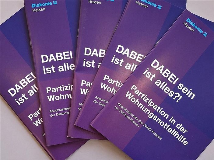 Broschüre "DABEI sein ist alles?!" liegen aufgereiht nebeneinander