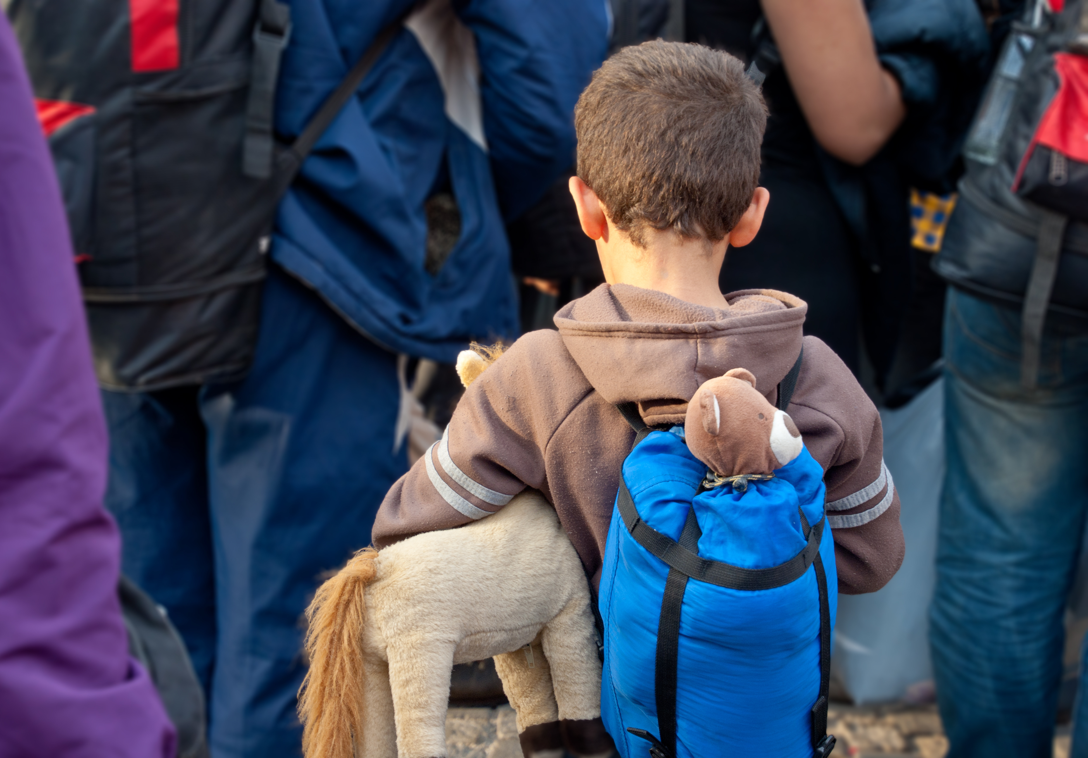 Junge mit Rucksack von hinten fotografiert